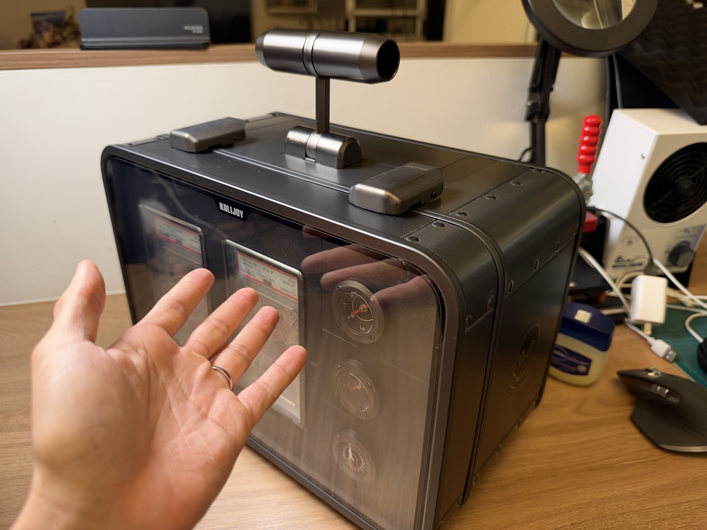 A hand held beside the Kalijoy K CASE showing its scale, roughly the width of two hand spans.